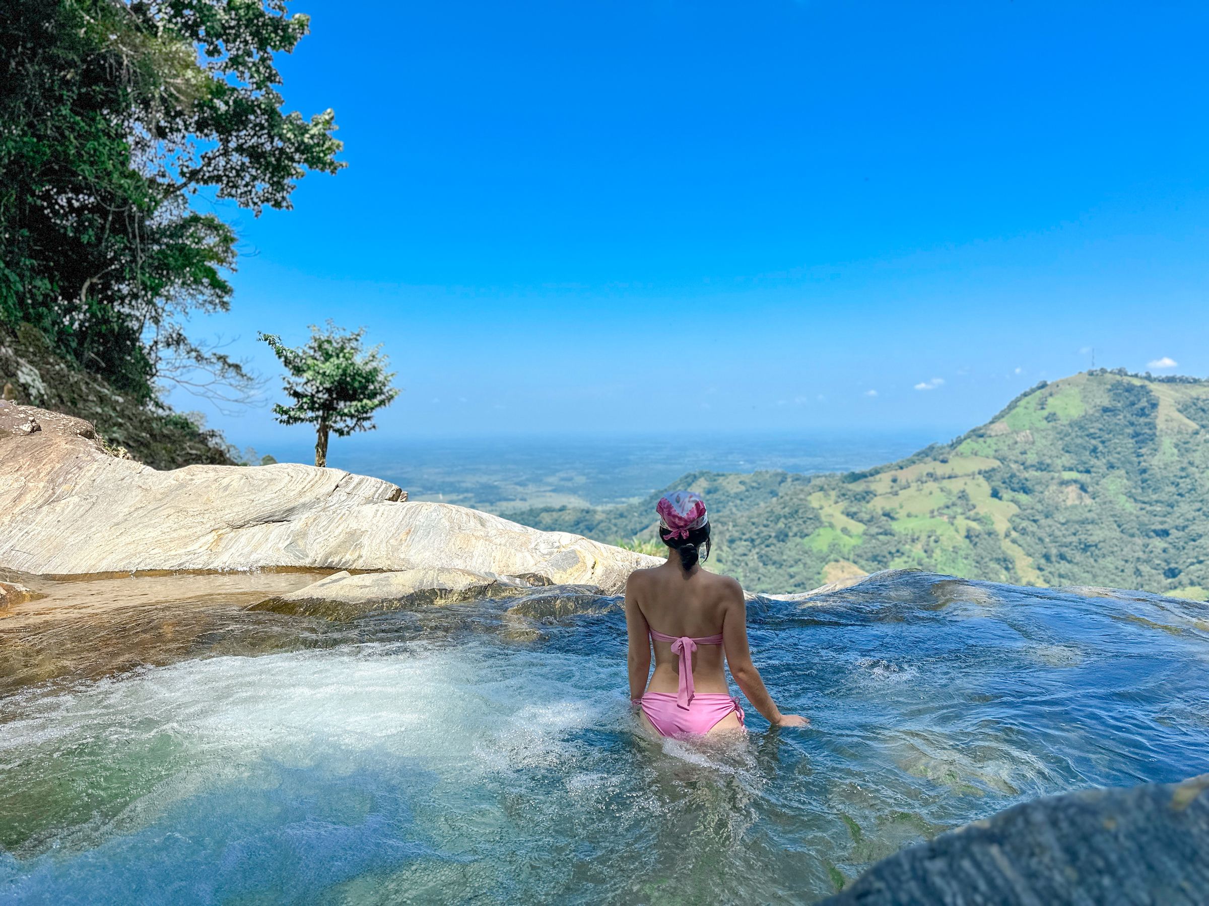 Huésped en una poza natural en lo alto de la cascada, con vista a las montañas del Caquetá